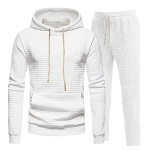 Detailed view of white men's tracksuit set featuring unique waffle texture and drawstring hoodie.