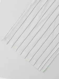 Vue détaillée de près d'un tissu en lin blanc avec des rayures verticales noires