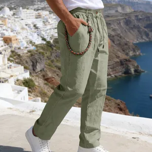 Détail du pantalon en lin vert sauge pour homme avec une chaîne de poche tressée décorative.