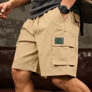 Detail view of khaki men's cargo shorts with large side flap pockets and drawstring waist