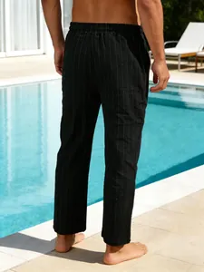 Vue détaillée de dos d'un pantalon en lin rayé noir pour homme au bord de la piscine