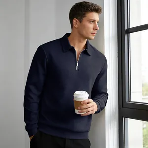 Model wearing a navy blue jacquard long-sleeve polo sweatshirt in a bright indoor setting.