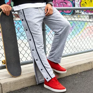 Dettaglio pantaloni sportivi grigi da uomo con bottoni a pressione in uno skatepark