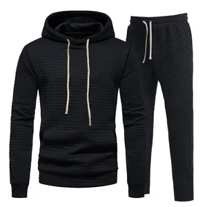 Detailed view of men's black tracksuit set featuring a premium jacquard waffle texture