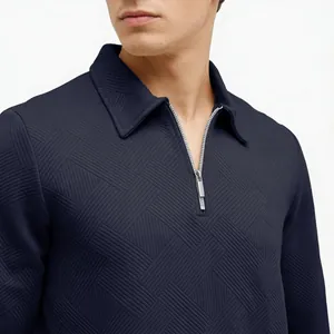 Close-up of men's navy blue long sleeve polo with textured jacquard and half-zip.