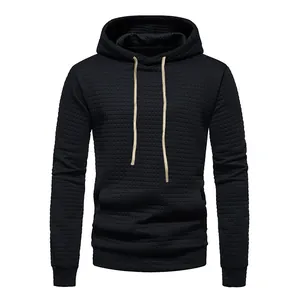 Detailed view of a black men's hoodie featuring a waffle jacquard texture and tan drawstrings