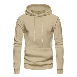 Macro detail of men's beige waffle knit hoodie featuring textured jacquard pattern