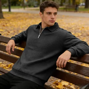 Close-up detail of men's textured jacquard quarter-zip polo sweatshirt in black color