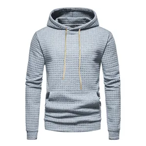 Close-up of grey waffle-knit jacquard hoodie with kangaroo pocket and drawstrings