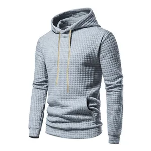 Detail view of men's gray waffle jacquard hoodie with drawstring hood and kangaroo pocket.