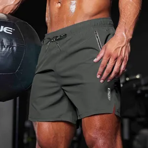 Detailed view of men's dark gray gym shorts featuring zipper pocket and side slit.