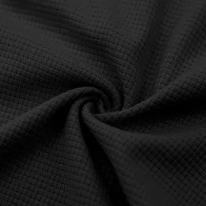Macro dettagliata del tessuto a trama nido d'ape nero per t-shirt sportiva da uomo.