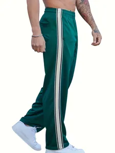 Detailed side view of dark green athletic track pants with white stripes and elastic waist.