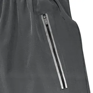Detailed close-up view of side zipper pocket with reflective strips on black sports shorts