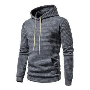 Detailed shot of grey waffle-textured men's hoodie with drawstring and front pouch