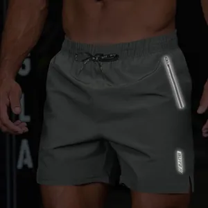 Close-up of men's dark grey athletic shorts with reflective zipper pocket and drawstring