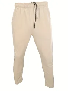 Close-up detail of men's beige slim-fit sports joggers with elastic drawstring waist.