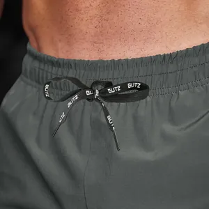 Detail of grey men's sports shorts featuring an elastic waistband and printed drawstring