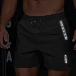 Macro view of men's black athletic shorts featuring reflective zipper and logo details