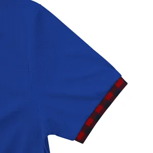 Dettaglio di una maglietta blu in maglia a nido d'ape con polsino a quadri rossi