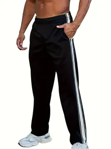 Detail of black men's athletic sweatpants with white side stripes and white sneakers