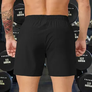 Rear view of comfortable men's loose black sports shorts in a professional gym setting