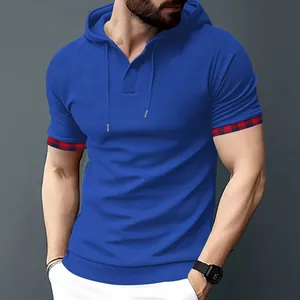 Dettaglio di una t-shirt blu con cappuccio, polsini a quadri e trama a nido d'ape