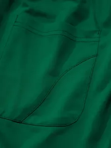 Close-up of green sports trousers showing durable pocket stitching and fabric texture
