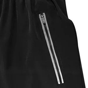 Detail of black men's sports shorts featuring a zipper pocket with reflective trim