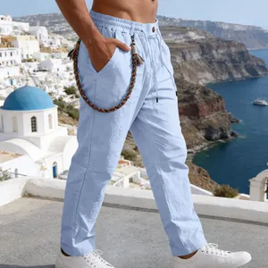 Détail du pantalon en lin bleu ciel avec accessoire corde tressée et taille élastiquée