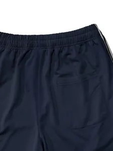 Close-up of men's navy blue sports pants showing elastic waist and back pocket