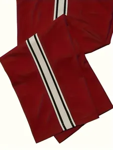 Detailed view of red men's athletic trousers featuring a white side stripe with black borders
