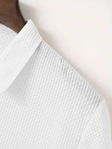 Detailed macro view of white waffle weave fabric on a men's classic polo shirt