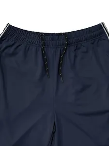 Close-up detail of navy blue sports pants with elastic waist and adjustable drawstring.