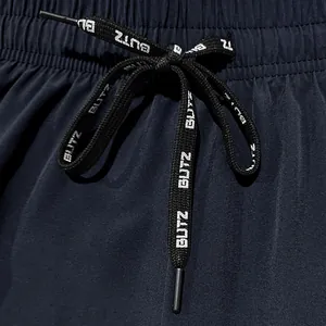 Detail view of men's athletic shorts featuring an elastic waist and printed BUTZ drawstring