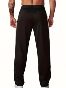 Rear view of black men's athletic sweatpants with white side stripes and elastic waist.