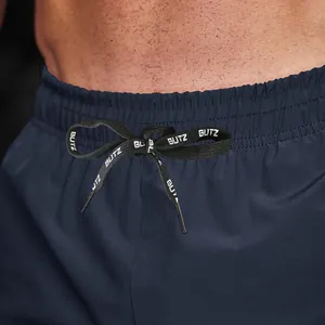 Detail of navy blue sports shorts with BUTZ printed drawstring and elastic waist