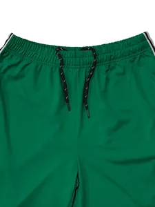 Detailed view of green men's sports trousers featuring elastic waist and drawstrings.