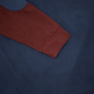 Close-up detail of a men's corduroy sweatshirt showing navy and burgundy ribbed cuffs