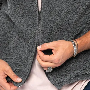 Detailed view of dark grey men's fleece jacket texture with premium metal zipper fastener