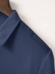 Close-up of blue textured waffle knit fabric on men's Polo shirt shoulder