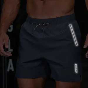 Detail of men's athletic shorts with reflective zipper pocket and branded drawstring.