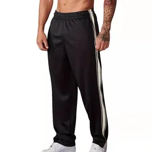 Close-up detail of black men's athletic sweatpants featuring white side stripes and elastic waist