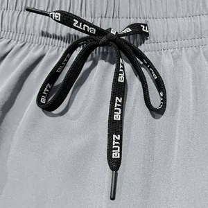 Close-up detail showing a black drawstring with BUTZ text print on grey sports shorts