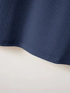 Detailed close-up view of navy blue waffle texture fabric for a men's heavy cotton Polo shirt