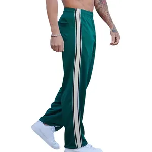 Detailed side view of green men's sports trousers with contrasting white side stripes.