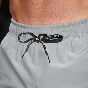 Close-up of grey men's sports shorts with black drawstring and white Blitz lettering