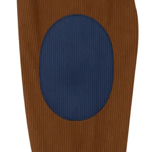 Close-up detail of brown corduroy sweatshirt with contrast blue oval elbow patch