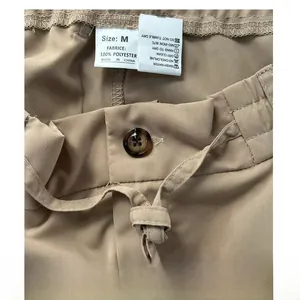 Close-up van het waslabel, de knoop en het trekkoord van de kaki casual herenbroek