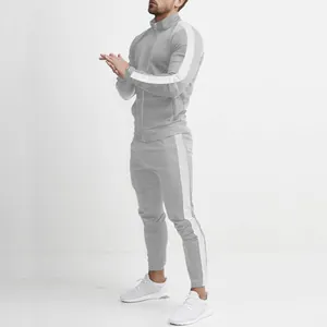 Detail view of a men's gray slim-fit tracksuit with white side stripes and stand collar
